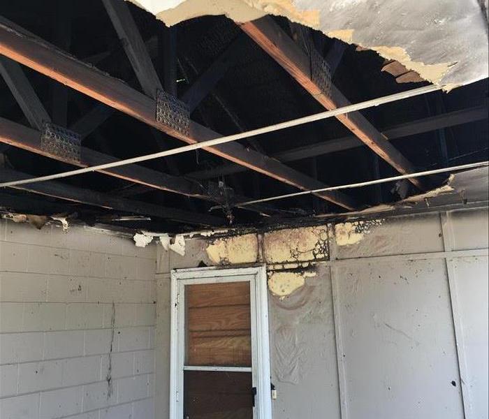 opened up ceiling on porch revealing torched and blackened roof trusses