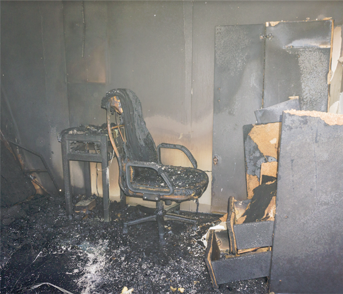 a fire damaged bedroom with soot covering everything